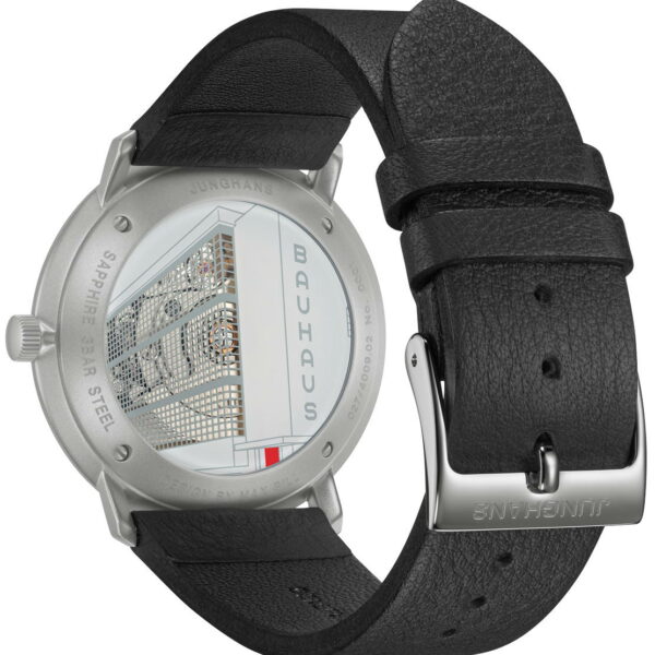 Nahaufnahme der Rückseite der Junghans Max Bill Automatik-Uhr mit „Bauhaus“- und Architekturlinien auf einem transparenten Gehäuse, mit schwarzem Lederarmband und silberner Schnalle. „Junghans“ ist um den Metallrand eingraviert.