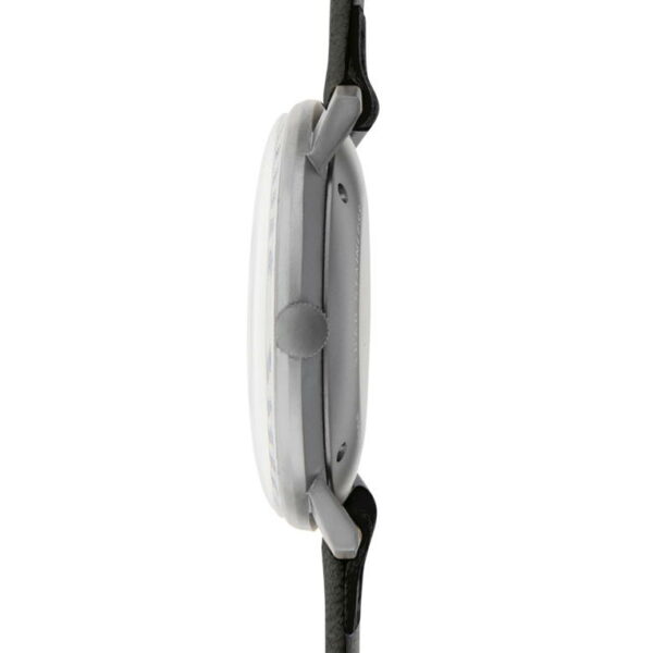 Die Seitenansicht der Junghans Max Bill Automatik zeigt ihr rundes weißes Zifferblatt, ihr schlankes Profil und ihr schwarzes Lederarmband. Das Stahlgehäuse und das minimalistische Design sind sichtbar, die Krone befindet sich auf drei Uhr.
