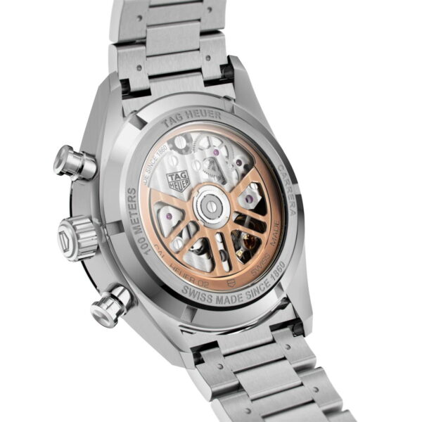 Eine silberne Armbanduhr mit transparenter Rückseite zeigt das komplizierte mechanische Uhrwerk im Inneren mit sichtbaren Zahnrädern und einem goldfarbenen Rotor. Die Uhr trägt die Marke „TAG Heuer“ und hat ein Metallarmband mit Gliedern.