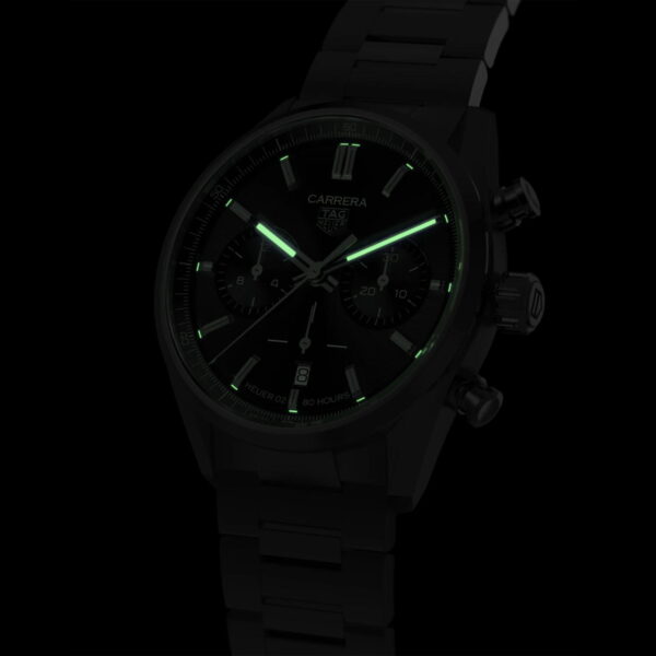 Eine schwarze Armbanduhr mit leuchtend grünem Zifferblatt und Markierungen im Chronographen-Design. Die Uhr hat ein Metallarmband und ist auf einem dunklen Hintergrund angebracht, wodurch die leuchtenden Elemente hervorgehoben werden.