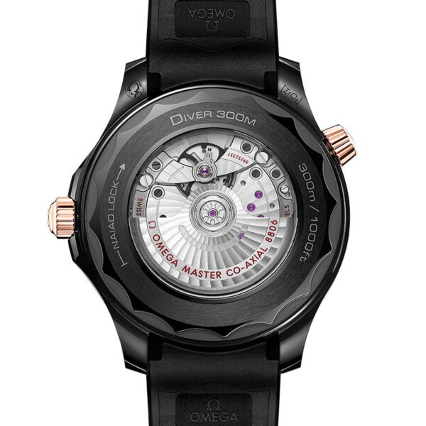 Das Bild zeigt die Rückseite einer Luxusarmbanduhr mit transparentem Gehäuse, das das komplexe mechanische Uhrwerk im Inneren offenbart. Die Uhr hat ein schwarzes Gummiarmband und zeigt einen Text, der darauf hinweist, dass es sich um ein 300-m-Tauchermodell mit einem Master Co-Axial-Chronometer handelt.