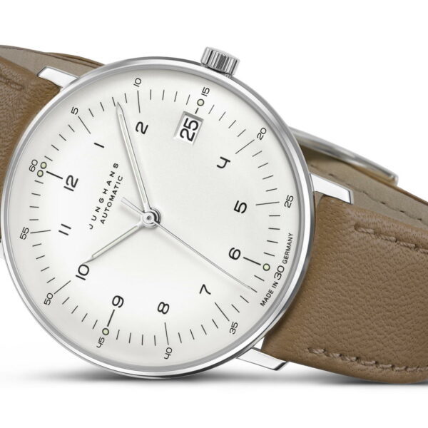 Die Junghans Max Bill kleine Automatik verfügt über ein schlankes Design mit einem braunen Lederarmband, einem silbernen Gehäuse und einem minimalistischen weißen Zifferblatt mit schwarzen Ziffern. Es verfügt über ein Datumsfenster auf der 3-Uhr-Position und ist leicht nach oben geneigt.
