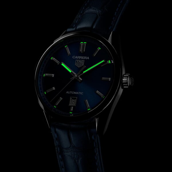Eine dunkle Armbanduhr mit leuchtend grünen Zeigern und Stundenmarkierungen auf schwarzem Hintergrund. Die Uhr verfügt über eine Datumsanzeige und ein Lederarmband.
