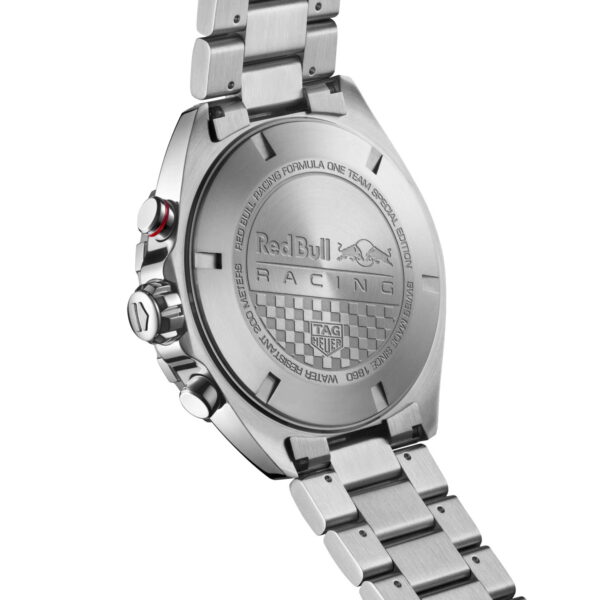Nahaufnahme einer Edelstahl-Uhrenrückseite mit dem Red Bull Racing-Logo und dem TAG Heuer-Branding. Das Gehäuse ist mit geometrischen Mustern und Text geprägt und die Uhr hat ein Metallarmband mit sichtbaren Knöpfen an der Seite.