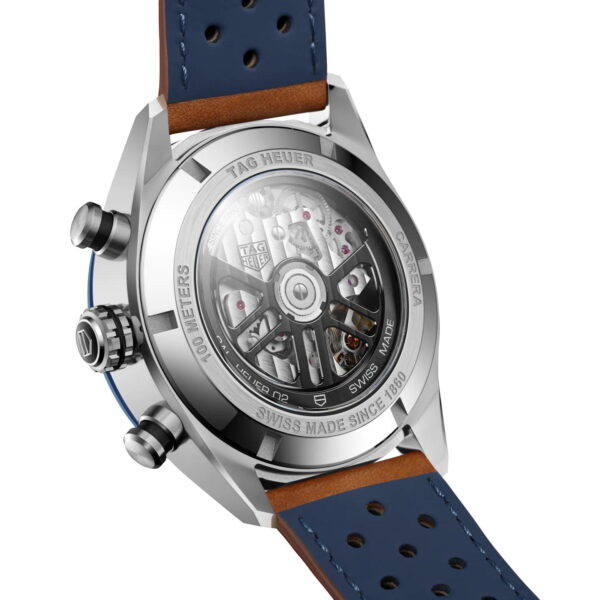 Rückansicht einer Luxusuhr mit transparentem Gehäuse, das die mechanische Innenmechanik zeigt. Die Uhr hat ein blaues perforiertes Armband und metallische Details an den Seiten, darunter zwei Knöpfe und eine Krone.