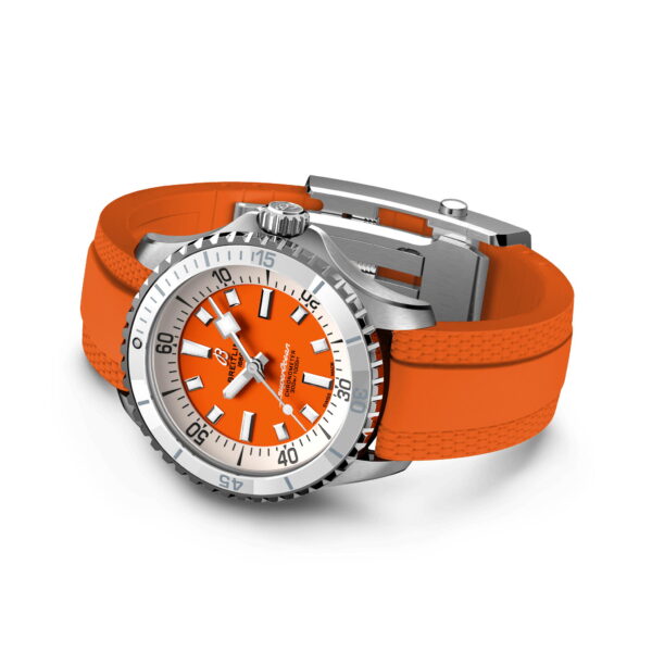 Eine silberne Armbanduhr mit leuchtend orangefarbenem Zifferblatt und passendem orangefarbenem Gummiarmband. Das Zifferblatt verfügt über kräftige weiße Stundenmarkierungen und eine drehbare Lünette mit Minutenmarkierungen. Das Armband hat in der Nähe der Ösen ein strukturiertes Muster.