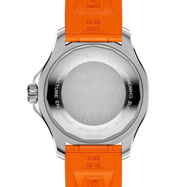 Das Bild zeigt die Rückseite einer Armbanduhr mit orangefarbenem Armband und silbernem Gehäuse. Die Rückseite ist mit verschiedenen Aufschriften geprägt, darunter „Manufacture en Suisse“ und „Certifie Chronometre“.