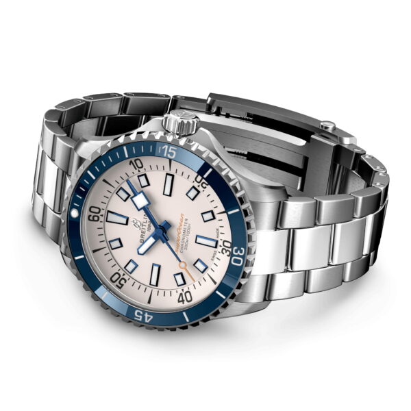 Eine Armbanduhr aus Edelstahl mit blau-weißem Zifferblatt. Die Uhr hat eine einseitig drehbare Lünette, leuchtende Zeiger und rechteckige Stundenmarkierungen. Das Armband besteht aus polierten Metallgliedern. Der Markenname ist auf dem Zifferblatt sichtbar.