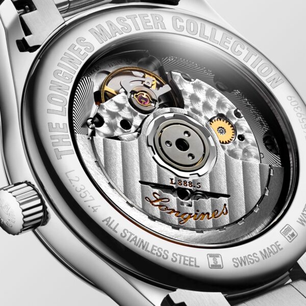 Das Bild zeigt die aufwendige Rückseite einer Uhr aus der Longines Master Collection, die ihr mechanisches Uhrwerk offenbart. Das silberne Edelstahlgehäuse ist mit technischen Details versehen und der Markenname ist in Gold in das Uhrwerk eingraviert.