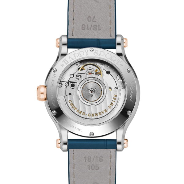 Das Bild zeigt die Rückseite einer Luxusarmbanduhr mit sichtbarem mechanischem Uhrwerk. Die Rückseite der Uhr zeigt komplizierte Zahnräder und ist in silbernes Metall mit zwei goldenen Knöpfen eingefasst. Das Armband ist aus Leder mit Nähten und eingraviertem Text.