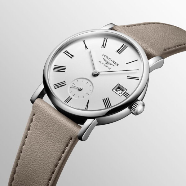 Silberne Armbanduhr mit weißem Zifferblatt, schwarzen römischen Ziffern und einem Datumsfenster auf der Drei-Uhr-Position. Sie hat ein Hilfszifferblatt auf der Sechs-Uhr-Position und ein hellbeiges Lederarmband. Die Uhr hat ein schlankes, minimalistisches Design.