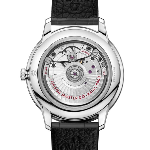 Rückansicht einer Omega-Armbanduhr, die das komplizierte mechanische Uhrwerk zeigt. Die Uhr hat ein silbernes Gehäuse und ein schwarzes Lederarmband. Im Inneren sind Gravuren, Zahnräder und Komponenten sichtbar, wobei „OMEGA MASTER CO-AXIAL 8800“ in den Mechanismus eingraviert ist.