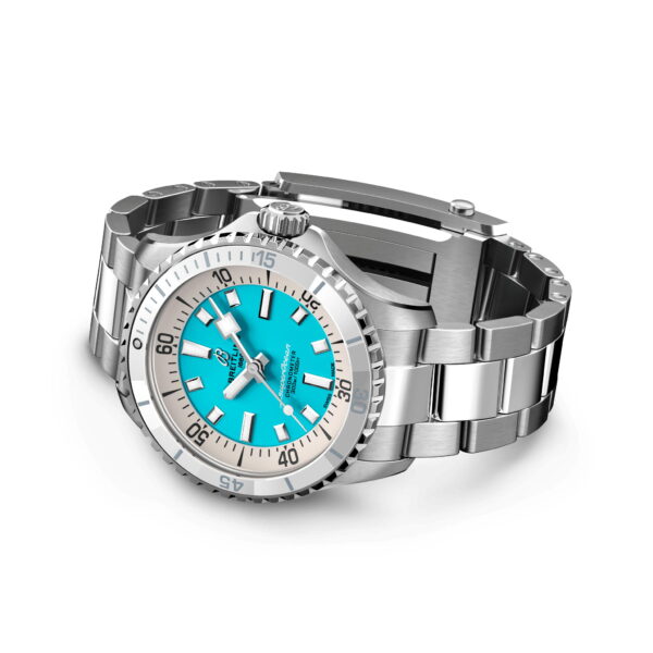 Armbanduhr aus Edelstahl mit türkisfarbenem Zifferblatt, schwarzen Stundenmarkierungen und einseitig drehbarer Lünette. Die Uhr verfügt über ein silbernes Metallarmband und das Markenlogo auf dem Zifferblatt. Die Zeit ist auf 10:10 eingestellt.