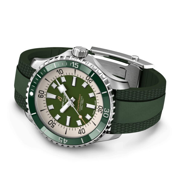 Eine Taucheruhr aus Edelstahl mit grüner Lünette und Zifferblatt sowie weißen Stundenmarkierungen und Zeigern. Sie hat ein grünes Gummiarmband und eine silberne Schnalle mit verschiedenen Texturen auf dem Band. Das Zifferblatt verfügt über ein Datumsfenster.