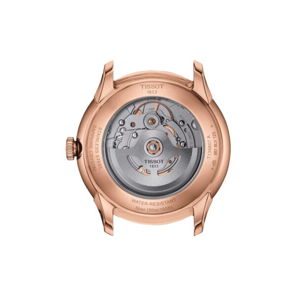 Das Bild zeigt die Rückseite einer Tissot-Uhr mit transparentem Gehäuse, das das mechanische Uhrwerk offenbart. Das Gehäuse ist aus Roségold und der innere Mechanismus ist silberfarben. Zahnräder und Inschriften sind sichtbar, darunter Angaben zur Wasserbeständigkeit und zur Marke.