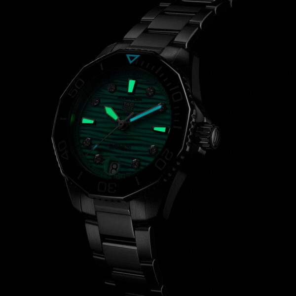 Die TAG Heuer Aquaracer Professional 300 ist eine schwarze Armbanduhr mit leuchtend grünen Zeigern und Markierungen auf einem dunklen Zifferblatt, ergänzt durch ein Metallarmband und eine detaillierte Lünette.