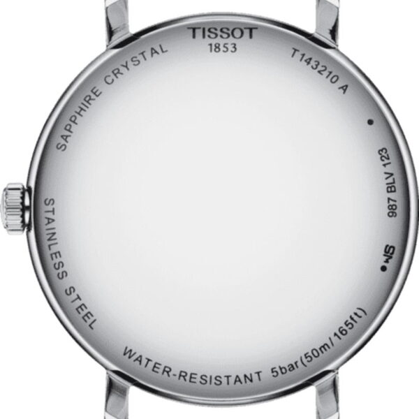 Die Rückseite des Uhrengehäuses der Tissot Everytime Lady ist silberfarben mit vier Ösen und trägt die Markierungen: „Saphirglas“, „Tissot 1853“, „T143210A“, „Edelstahl“, „Wasserdicht 5 Bar (50 m/165 Fuß)“ und „987 BLV 123“.