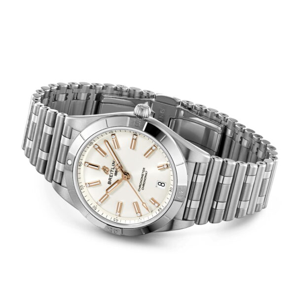 Die Breitling Chronomat Automatic 36 ist eine silberne Armbanduhr mit Edelstahlarmband und weißem Zifferblatt mit goldenen Stundenmarkierungen, einer Datumsanzeige und einem markanten Markenlogo. Die Uhrzeit auf der Uhr ist auf 10:09 eingestellt.