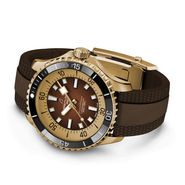 Die Breitling Superocean Automatic 44 ist eine gold-braune Armbanduhr mit drehbarer Lünette, braunem Zifferblatt mit weißen Stundenmarkierungen und einem gewebten Gummiarmband mit Faltschließe. Die Zeit ist auf 10:10 eingestellt.