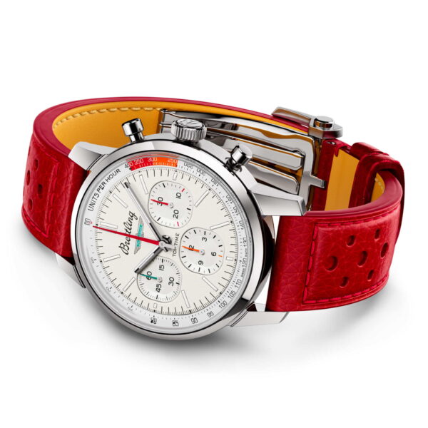 Die Breitling Top Time B01 Ford Thunderbird ist eine polierte silberne Armbanduhr mit einem weißen Zifferblatt mit mehreren Hilfszifferblättern und Chronographenfunktion, ergänzt durch ein leuchtend rotes perforiertes Lederarmband mit gelber Unterseite und ausgestattet mit einer eleganten Krone und Drückern.