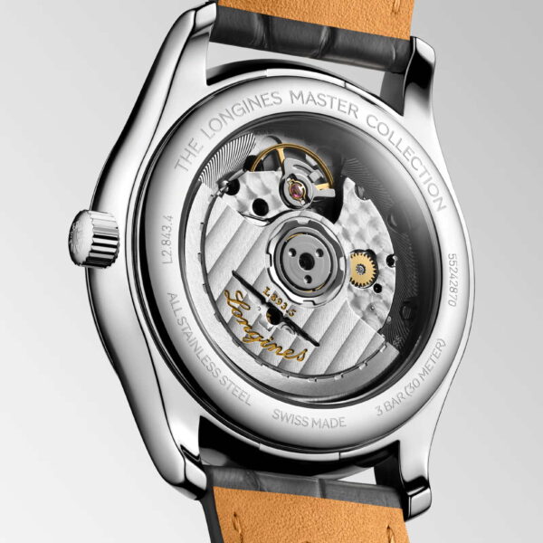 Das Bild zeigt die Rückseite einer Uhr aus der Longines Master Collection mit einem transparenten Gehäuse, das das komplexe mechanische Uhrwerk zeigt. Das silberne Gehäuse enthält einen eingravierten Text und ist mit einem braunen Lederarmband versehen.