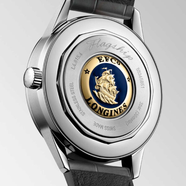 Das Bild zeigt die Rückseite einer silbernen Longines-Uhr mit schwarzem Lederarmband. Sie verfügt über ein eingraviertes Logo, das ein Schiff auf blauem Hintergrund darstellt, umgeben von den Worten „EFCo“ und „LONGINES“. Das Gehäuse ist mit „Stainless Steel“ und „Swiss Made“ gekennzeichnet.
