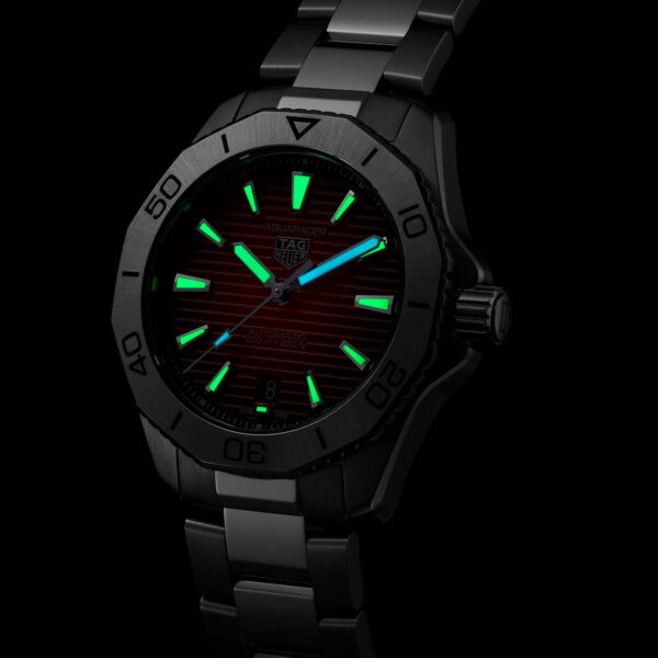 Eine schwarze Armbanduhr mit leuchtend grünen Stundenmarkierungen und Zeigern. Die Uhr verfügt über ein Metallgliederarmband und eine Datumsanzeige. Der dunkle Hintergrund hebt die leuchtenden Elemente hervor.