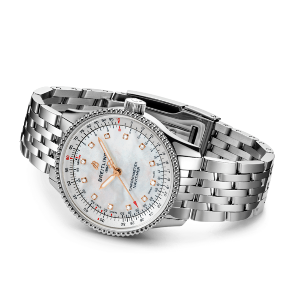 Die Armbanduhr Breitling Navitimer Automatic 35 verfügt über ein Edelstahl-Gliederarmband. Sie verfügt über ein weißes Zifferblatt mit roten und silbernen Markierungen, leuchtenden Zeigern, Diamant-Stundenmarkierungen, einer geriffelten Lünette und einer markanten Krone.