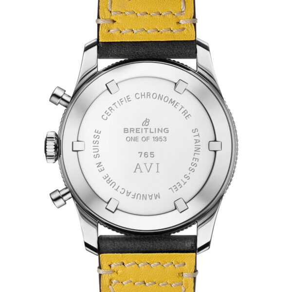 Das Bild zeigt die Rückseite einer Breitling Classic AVI 1953-Uhr mit eingraviertem Text: „CERTIFIE CHRONOMETRE“, „MANUFACTURE EN SUISSE“ und „STAINLESS STEEL“. Die Uhr verfügt über ein gelbes Lederarmband mit schwarzen Kanten und seitlichen Metalldruckknöpfen.