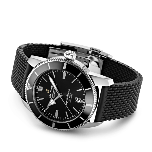 Die Breitling Superocean Héritage II B20 46 ist eine schwarze analoge Armbanduhr mit strukturiertem Armband und silbernem Gehäuse. Sie verfügt über silberne Stundenmarkierungen, leuchtende Zeiger, ein Datumsfenster und den Schriftzug „Breitling“ und präsentiert sich in einem polierten und eleganten Design.