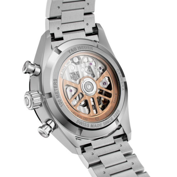 Das Bild zeigt die Rückseite einer TAG Heuer Carrera Chronographenuhr, deren automatisches Uhrwerk durch ein transparentes Saphirglas sichtbar ist. Das Edelstahlgehäuse und das silberfarbene Armband heben das komplizierte Innenleben hervor.