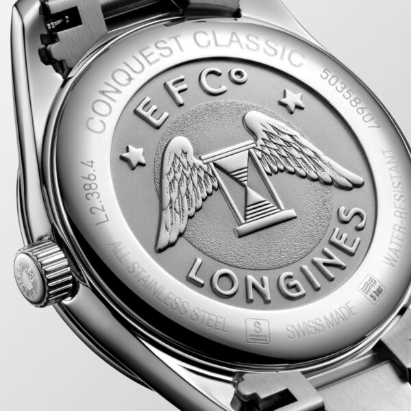 Auf der Rückseite der in der Schweiz gefertigten Longines Conquest Classic-Uhr aus Edelstahl sind die Gravuren „CONQUEST CLASSIC“, „EFC“, „LONGINES“ und „WATER RESISTANT“ sowie ein Emblem mit Flügeln und Sternen zu sehen, wodurch eine sichtbare Lünette und Krone hervorgehoben werden.