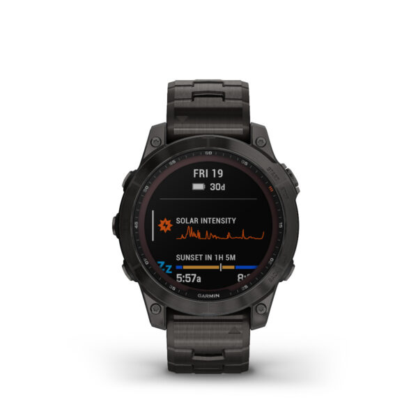 Die digitale Uhr Garmin Fenix 7 Sapphire Solar hat ein schwarzes Armband und zeigt „Fri 19“ an. Sie zeigt Daten zur Sonnenintensität, ein Diagramm, die Sonnenuntergangszeit von „1h 5m“ und ihre Zeiger zeigen 6:57 an. Die Marke Garmin ist unten sichtbar.