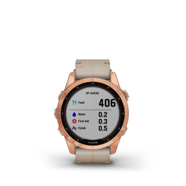 Die Smartwatch Garmin Fenix 7S Sapphire Solar Edition mit roségoldener Lünette und beigem Armband zeigt eine Wanderoberfläche mit „Up Ahead“ und Symbolen für Essen, Wasser, Erste Hilfe und Ziel. Sie zeigt Entfernungen an: 406 Meilen bis zum Essen, 0,2 bis zum Wasser, 0,3 bis zur Ersten Hilfe und 0,5 Meilen bis zum Ziel.
