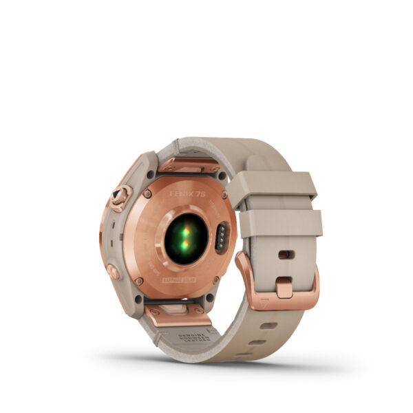 Rückansicht einer beige- und roségoldfarbenen Garmin Fenix 7S Sapphire Solar Edition-Smartwatch mit grünem Sensorlicht. Das Armband ist beige mit einer Metallschließe und der Modellname ist nahe der Oberkante eingraviert.