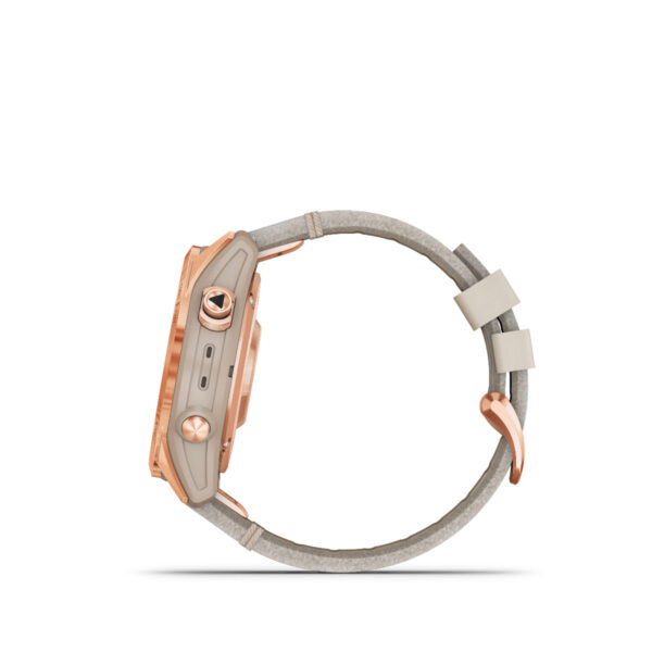 Die Garmin Fenix 7S Sapphire Solar Edition wird im Seitenprofil gezeigt und präsentiert ihr roségoldenes Design mit einem beigen Band. Sie verfügt über zwei seitliche Tasten, einen kleinen Anschluss und besticht durch einen minimalistischen, modernen Look. Das Band ist mit einem Schnallenverschluss gesichert.