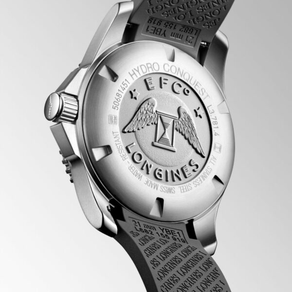 Die Rückseite der Longines HydroConquest zeigt ein rundes Silbergehäuse mit der Gravur „Hydro Conquest Longines“ um ein geflügeltes Emblem herum. Ein sichtbares Armband zeigt weitere Gravuren, alle vor einem eleganten Hintergrund mit hellem Farbverlauf.