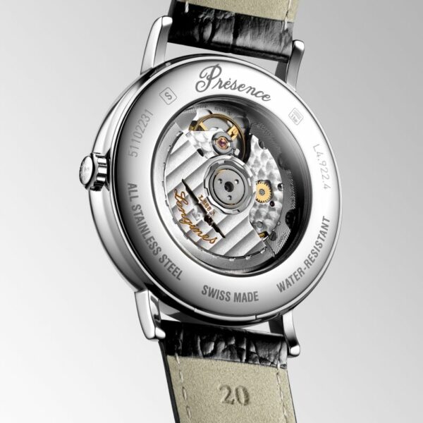 Das Bild zeigt die Rückseite einer Longines Présence Automatic-Armbanduhr. Durch das transparente Gehäuse sind komplizierte mechanische Komponenten und Aufschriften wie „Swiss Made“ und „Water-Resistant“ zu sehen. Das Armband ist aus schwarzem Leder.