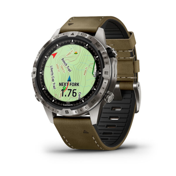 Das Garmin Marq Adventurer 2.Gen. verfügt über ein robustes Design mit einem grauen Metallrahmen und zeigt einen Kartennavigationsbildschirm mit 1,76 Meilen bis zur „nächsten Abzweigung“ und einen Kompass, ergänzt durch ein olivgrünes Armband mit weißen Nähten.