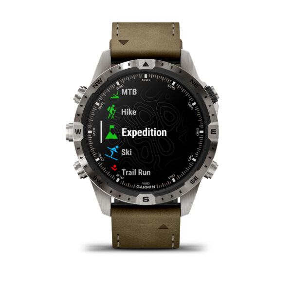 Die Garmin Marq Adventurer 2.Gen. Smartwatch verfügt über ein braunes Lederarmband und einen Bildschirm mit Aktivitätsoptionen wie MTB, Wandern, Expedition, Ski und Trail Run. Die Lünette enthält Kompassrichtungsmarkierungen.