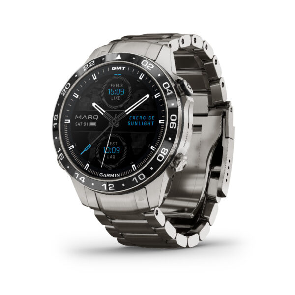 Die Garmin Marq Aviator 2.Gen, eine Smartwatch aus Edelstahl, verfügt über ein rundes Zifferblatt, auf dem Uhrzeit, Datum (Sa 01) und Wetterdetails angezeigt werden („Fühlt sich an wie 15:09“, „Übung im Sonnenlicht“). Sie verfügt über ein Armband aus gebürstetem Metall und aufwendige Markierungen auf der Lünette.