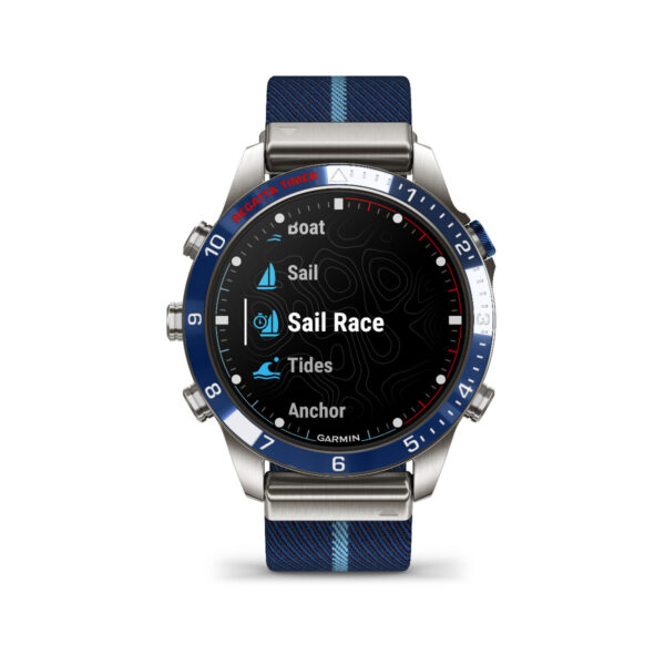 Die Garmin Marq Captain 2.Gen. Smartwatch verfügt über eine blaue und silberne Lünette, eine Benutzeroberfläche im Segelboot-Design und ein blaues Armband mit hellblauen Streifen. Sie bietet die Funktionen „Segelrennen“, „Segeln“, „Gezeiten“ und „Anker“.