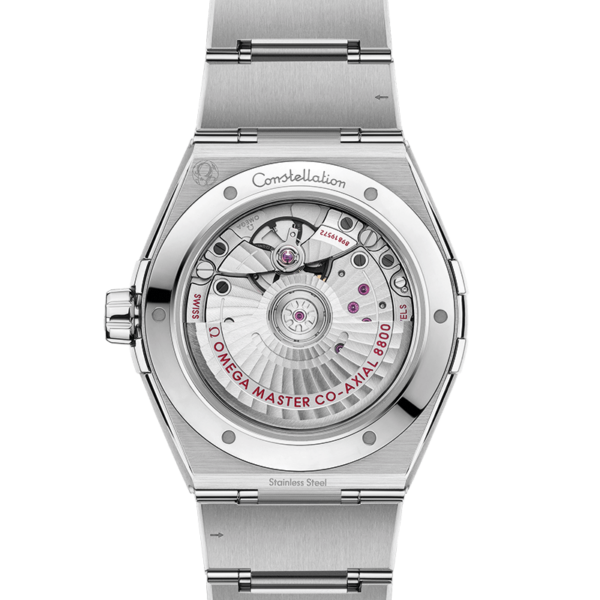 Die OMEGA Constellation ist eine silberne Luxusarmbanduhr mit sichtbarem Mechanismus auf der Rückseite, der komplizierte Zahnräder offenbart. Auf dem polierten Edelstahlarmband sind das Omega-Logo und die Aufschrift „Master Co-Axial“ zu sehen.