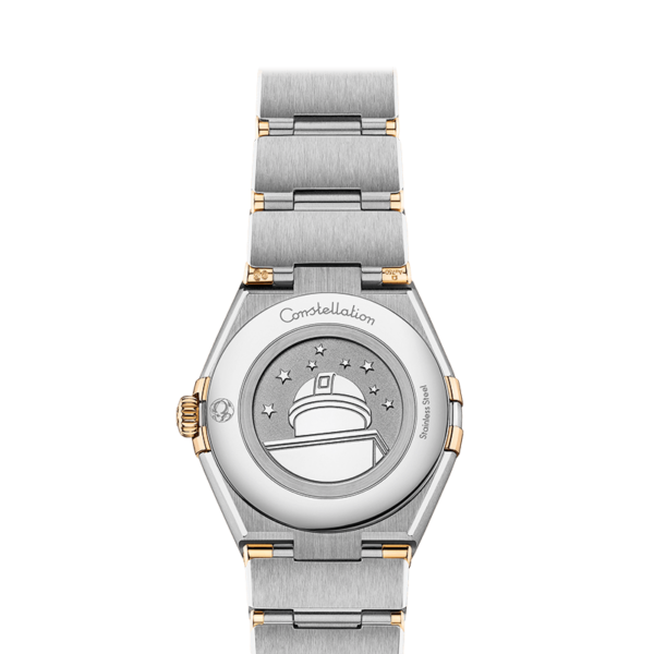 Die Luxusarmbanduhr OMEGA Constellation Manhattan B zeigt auf der Rückseite ein eingraviertes Observatorium und Sterne sowie ein silbernes und goldenes Metallarmband. Die Kanten weisen eine Mischung aus gebürsteten und polierten Oberflächen auf und tragen das Wort „Constellation“.