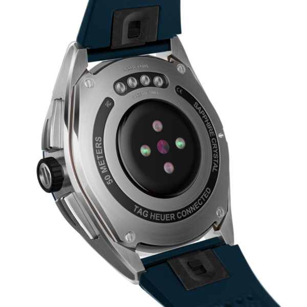 Das Bild zeigt die Rückseite einer TAG Heuer Connected E4-Smartwatch mit Metallgehäuse, zentralen Sensoren, einem schwarzen Band und Markierungen, die ihre Wasserdichtigkeit bis 50 Meter und ihr Saphirglas zeigen.