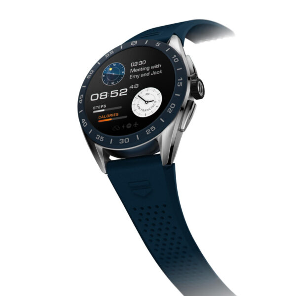 Die TAG Heuer Connected E4 ist eine elegante, moderne Smartwatch mit blauem Armband und Metallgehäuse. Sie verfügt über eine digitale Anzeige für Uhrzeit, Kalenderereignisse, Schritte und Kalorien. Das Zifferblatt hat zwei Zifferblätter für Uhrzeit und Wetter auf weißem Hintergrund.