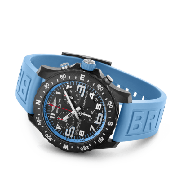 Breitling Endurance Pro: Schwarze Armbanduhr mit geprägtem blauem Kautschukarmband, schwarzem Zifferblatt mit weiß/roten Details, Zahlen und Himmelsrichtungen auf der Lünette und silbernen Seitentasten.