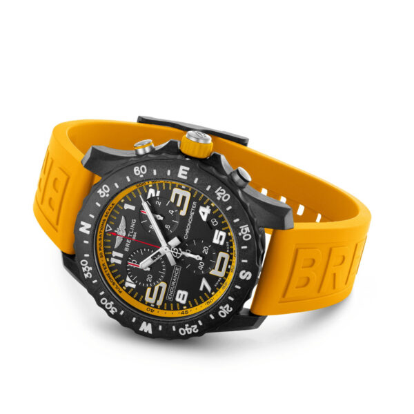 Die Breitling Endurance Pro ist eine sportliche Armbanduhr mit schwarzem Zifferblatt mit mehreren Hilfszifferblättern und gelbem Außenring. Sie verfügt über weiße Ziffern und wird mit einem kräftigen gelben Armband geliefert, das mit strukturierten „BR“-Buchstaben geprägt ist, was für ein robustes Design sorgt.