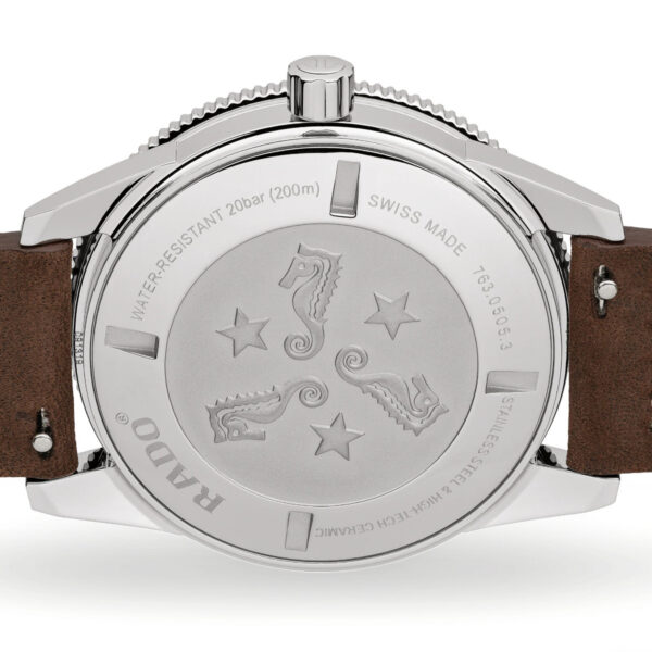Die Rückseite der Rado Captain Cook Automatik zeigt ein Edelstahlgehäuse mit Seepferdchen, Sternen, einem Text, der die Wasserdichtigkeit bis 200 Meter bestätigt, Schweizer Handwerkskunst und anderen Details. Sie wird mit einem braunen Lederarmband geliefert.