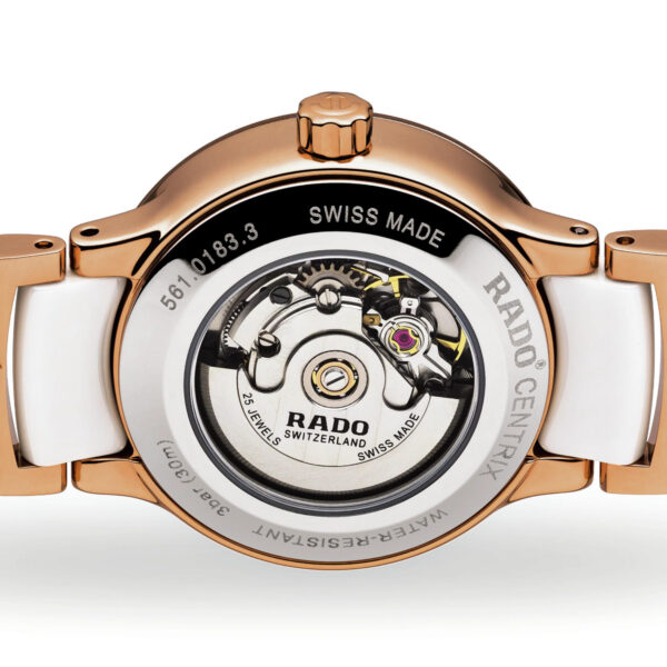 Nahaufnahme der Rückseite einer Rado Centrix Diamonds-Uhr, die ihr transparentes Gehäuse mit sichtbarer Mechanik zeigt. Das Design umfasst goldfarbene Metall- und weiße Keramikglieder mit den Worten „Swiss Made“ und „Water Resistant“.